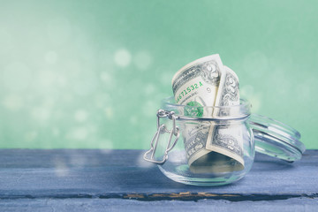 Two dollars in the jar on a green background. Savings money concept