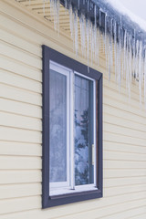 Icicles hang from the roof of a private house in winter