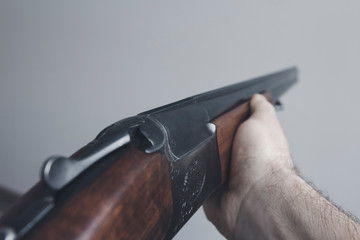 Men's hands aim a gun