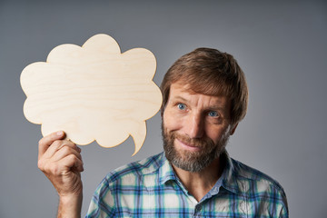Studio portrait of smiling mature man holding speech bubble