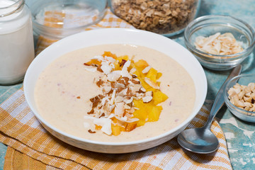 smoothie bowl with mango, coconut and nuts