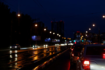 Naklejka na ściany i meble View of night city, cars on the street, blurred light.