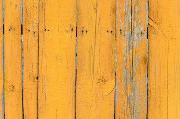 Old yellow wooden wall with cracked paint layer, detailed background photo texture