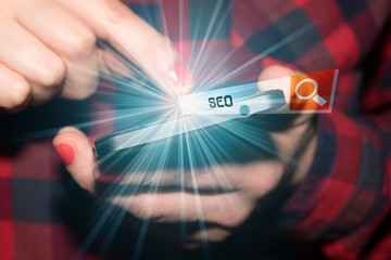 Eine Frau am Smartphone informiert sich über SEO Search Engine Optimization