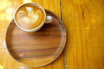 Hot latte art on wooden tray