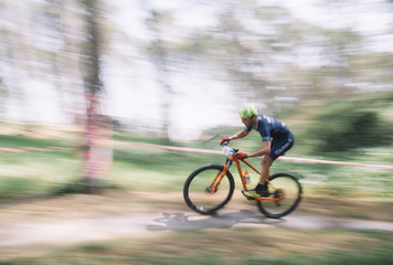 Fototapeta na wymiar Cadiz, Spain - 24 March 2019: Participants of the third edition of the mountain bike championship. Photographs made with the sweeping technique.