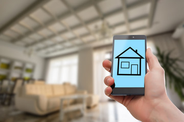 Hand holding mobile phone with house sale offer