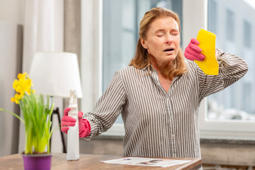 Housewife wearing gloves having sensitivity to cleaning detergents
