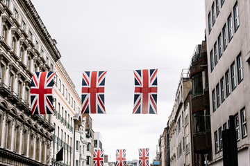 Union Jack flags hanging between rows of buildings in London, England