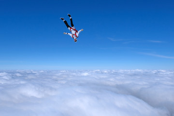 Skydiver is going to dive into the clouds.