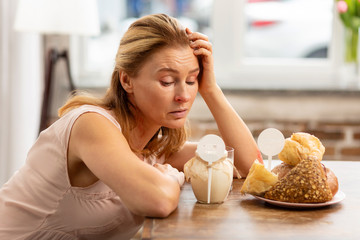 Woman looking at dairy and pastry products having strong allergy