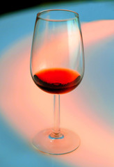 One glass of red wine on bright color background.