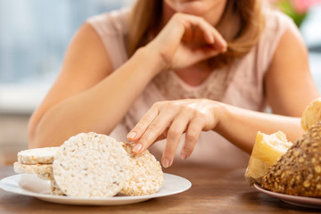 Blond-haired woman eating crisps not bread because of allergy