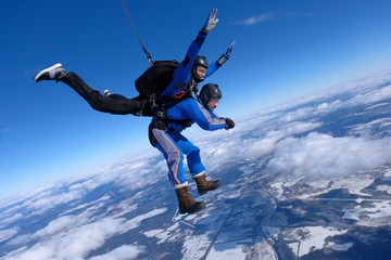 Tandem skydiving. Two guys are having fun in the sky.