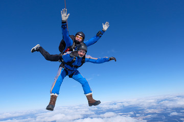 Fototapeta na wymiar Tandem skydiving. Two guys are having fun in the sky.