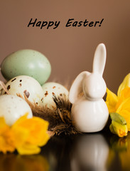 Small white rabbit figurine with easter eggs and narcissus