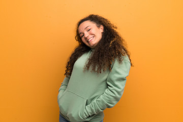 Happy Teenager girl over ocher wall.