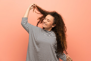 Happy Teenager girl over pink wall.