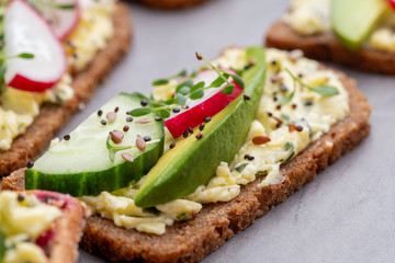 Sandwiches with cream cheese, vegetables and salami.