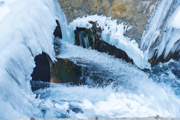 Frozen water channel. Mountain river in winter. Icing on the bank of the stream. Bypass channel....