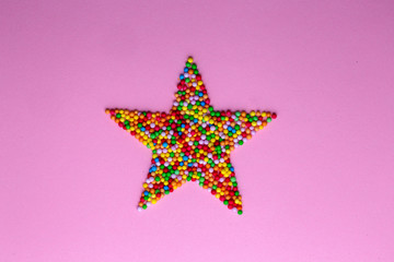 Obraz premium Star shape made of hundreds and thousands on a pink background