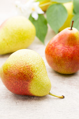 Fresh pears with leaves in a on wooden background.