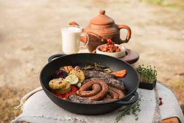 Grilled different meat sausages with vegetables and spices