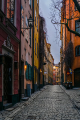 Fototapeta na wymiar Old cobbled narrow street with colorful houses in Stockholm in the morning - 9