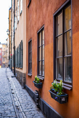 Fototapeta na wymiar Old cobbled narrow street with coilorful houses in Stockholm in the morning - 7