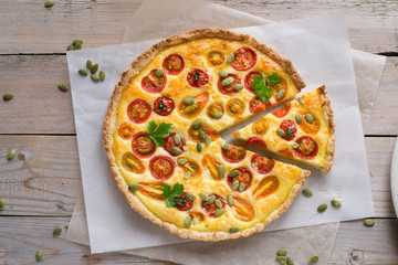 Tomato tart with pumpkin seeds on wooden table