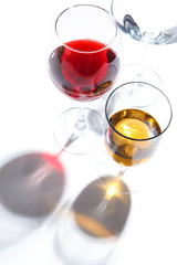 Glass glasses with drinks of different colors on a white background. Top view. The concept of an alcoholic cocktail.