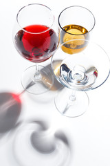 Glass glasses with drinks of different colors on a white background. Top view. The concept of an alcoholic cocktail.