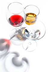 Glass glasses with drinks of different colors on a white background. Top view. The concept of an alcoholic cocktail.