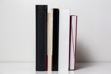 Fototapeta premium Reading books arranged on a white table. Background texture.