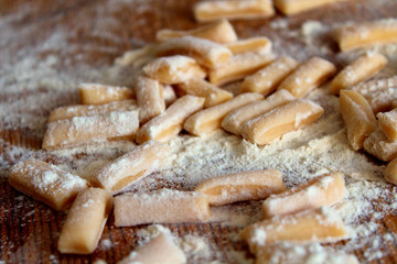 Sliced dough and flour on a wooden board. Close-up. Background. Texture.