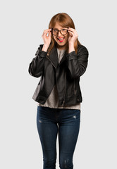 Young redhead woman with glasses and surprised over isolated grey background