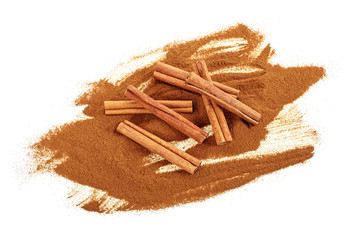 Ground cinnamon and cinnamon sticks on a white background