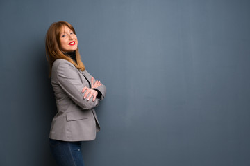 Redhead business woman keeping the arms crossed in lateral position while smiling