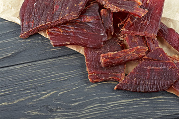 Beef jerky on a wooden board, close-up.