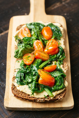 Hummus on Wholegrain Toast with Sauteed Spinach and Cherry Tomatoes