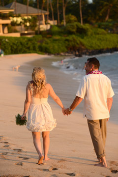 Couple walking on the beach holding hands