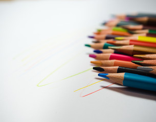 assortment of colored pencils on a white background, with colored lines arranged randomly. low Depth of field