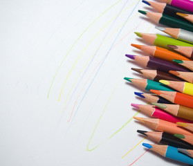 assortment of colored pencils on a white background, with colored lines arranged randomly