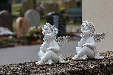 Two miniature angels on a stone wall