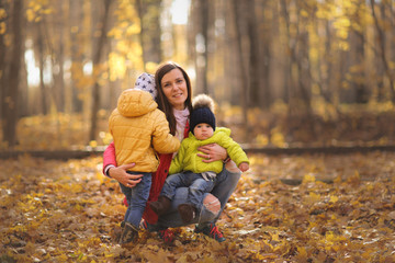 tender mother with two sons hugging. autumn park