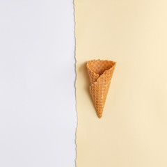 Waffle cone for ice cream on a paper background. Top view. Copy space. Minimalistic concept.