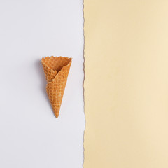 Waffle cone for ice cream on a paper background. Top view. Copy space. Minimalistic concept.