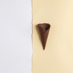 Waffle cone for ice cream on a paper background. Top view. Copy space. Minimalistic concept.