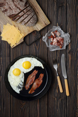 Bacon and eggs on wooden brown background. bread, cheese
