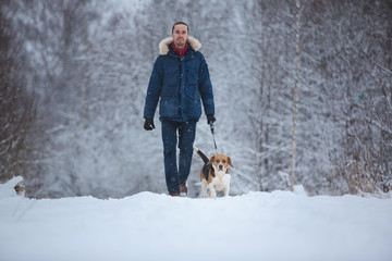 Man walking with dog beagle in winter. Snowing day